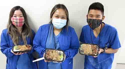 Ann-Janin Bacani '18 and her co-workers showing their lunch their received from donors