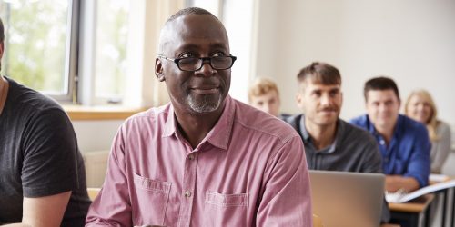 An adult African American military student in a classroom setting using a digital tablet