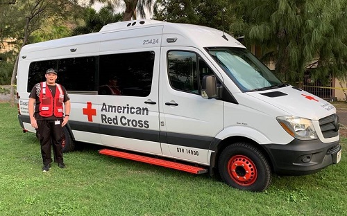 Timothy Duston standing in front of the Red Cross van