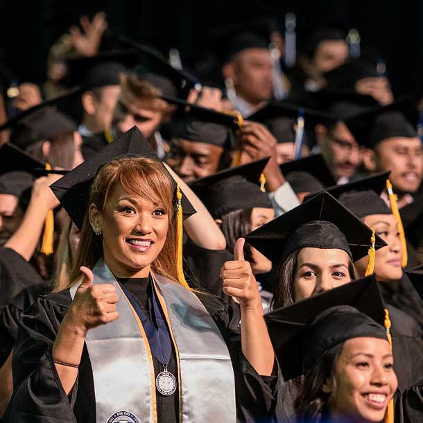 Chaminade University graduate smiling at camera and giving the thumbs up