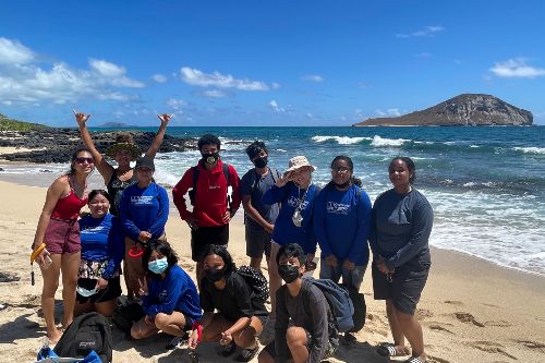 high school students at the beach looking at marine life during the marine science summer institute