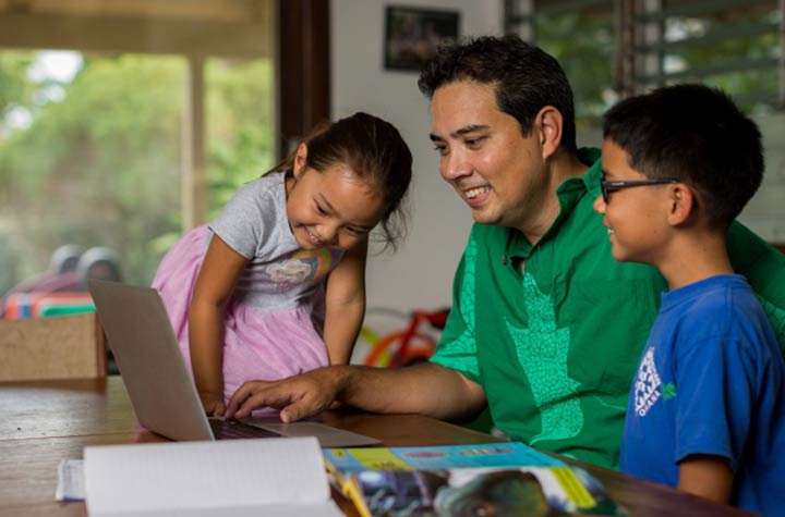 Dad with two children doing online learning