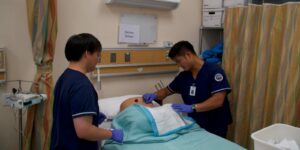 male nursing students learning on patient simulation dummy