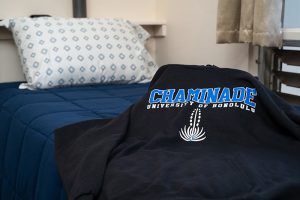 Chaminade University shirt on bed in student dorm at Hale Lokelani