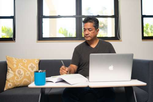 An online undergraduate student does his class assignment on his laptop