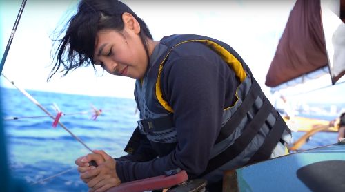 Cara Guiterrez winding a lever on the Golden Rule Peace Boat