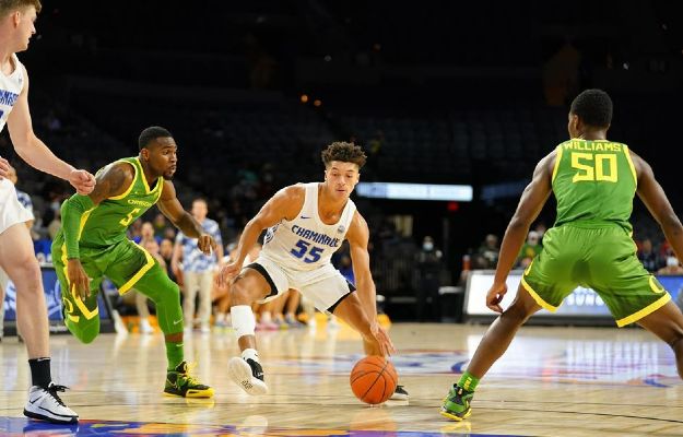 Chaminade basketball player dribbling past an Oregon player