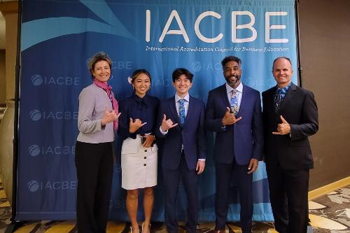 The Chaminade team posing in front of the IACBE banner at the IACBE Business Case Competition