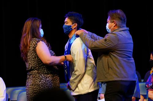 Nursing students receiving his stole and pin from her parents during the Nursing Pinning Ceremony