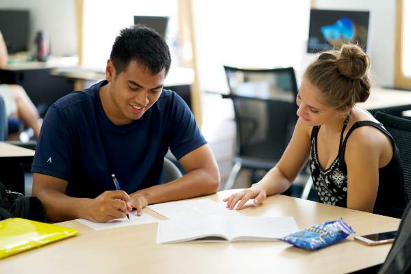 A student tutoring another student in the Kokua Ike center