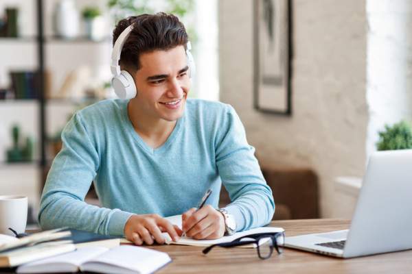 student making notes during online lesson