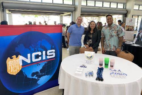 Chris Meana, right, and Kay Een promote NCIS at a recruitment affair.