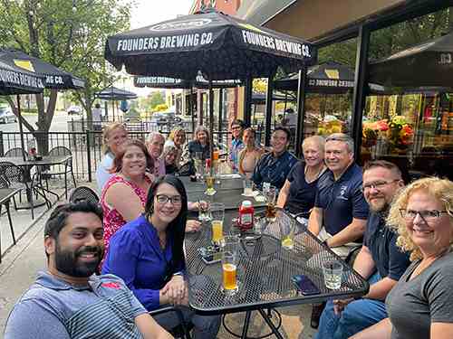 Staff and faculty from Chaminade and University of Dayton gather for dinner at an outdoor patio.