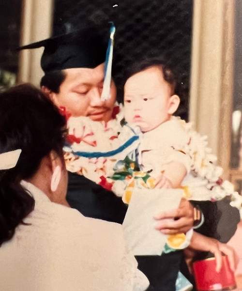 Dr. Thomas Shieh with his daughter Beverly in his arms after the Chaminade graduation ceremony.