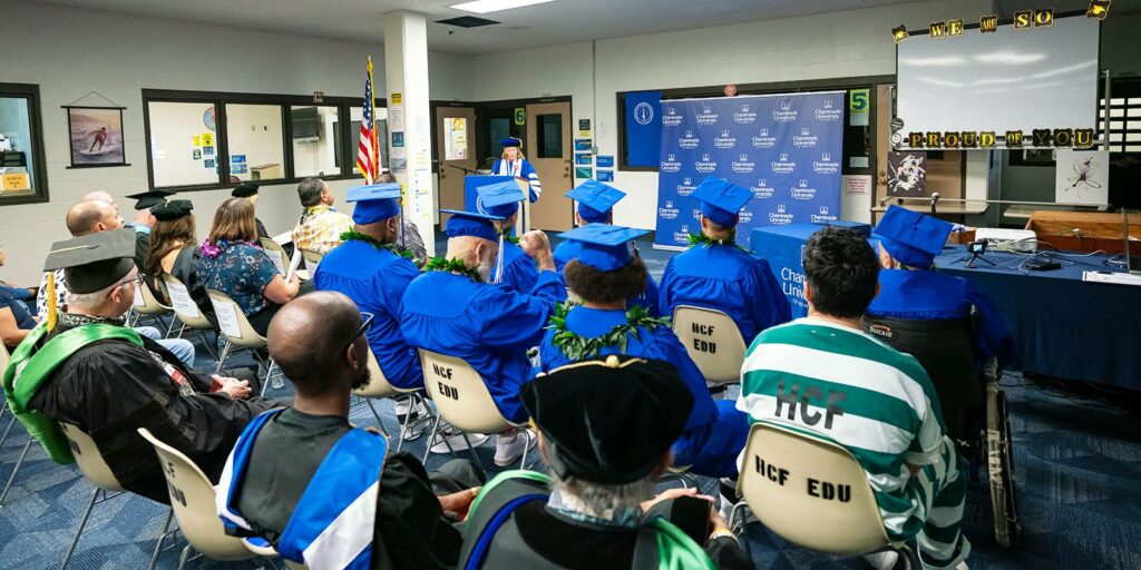 Chaminade University President Dr. Lynn Babington congratulates graduates during the Halawa Correctional Facility Commencement.