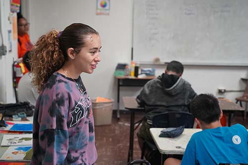 Roselyn Macias looks on as Jarrett Middle School students complete the task of creating their personal budgets.