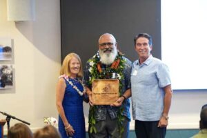 Athletics Director Tom Buning and Chaminade President Dr. Lynn Babington pose next to Hall of Fame inductee, Chico Furtado '80.