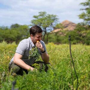 Ethan West bites into a carrot to check on its ripeness.