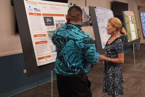 Dr. Lynn Babington listened to what Kole Nagai had to say about his research findings during the 22nd Annual Na Liko Na'auao Symposium.