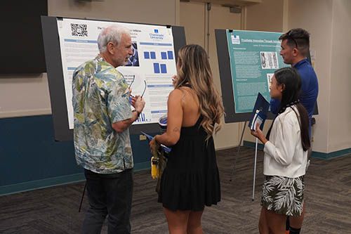 Professor Tracy Trevorrow, Ph.D., discusses the research findings of Clara Slate-Liu, left, and Leila-Jayne Casison.