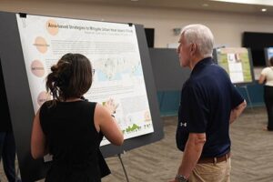 Sarah Carroll explains her research to Fr. Martin Solma during the Na Liko Na'auao Symposium.