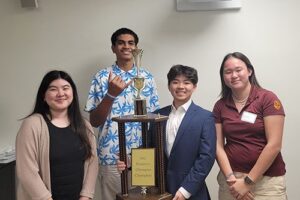 Nanakuli junior, Vai Fanuaea, flashing shaka, and Maryknoll School students pose with their trophy.