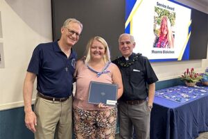 Frs. Chris Wittman and Martin Solma congratulate Moanna Blaksteen for her Service Award.