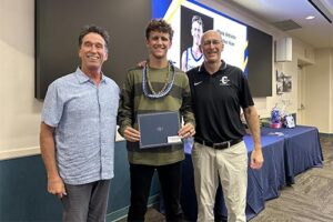 Athletic Director Tom Buning and Men's Basketball Coach Eric Bovaird congratulate guard Ross Reeves ’26.