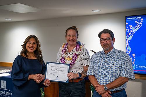 School of Business and Communication Interim Dean Annette Santos and Assistant Dean Asoke Datta congratulate Caryl Tracy-Metz for her MBA Academic Achievement in Master of Business Administration Award.