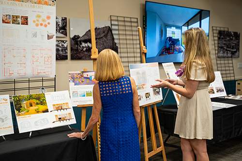 Jenna Dahl explains her ArtArc presentation to Chaminade President Lynn Babington, Ph.D.