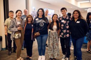 Drs. Hans Chun, Dale Fryxell and Saint Louis teacher Charlie Clausner, in the background from left, mingle with alumni Carina Lee MEd '23, Be-Jay Kodama '86 and MBS '16, Brittaney Fitzgerald '22, Nicole Kegine Aguinaldo '24, Marlon Francisco '24 and Audrey Pilar '24.