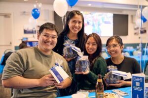 Alumni, from left, Derek Liu '17 and MBA '19, Sabrina Hallabay '19, Jennifer Tolentino '18 and MBA '21 and Christine Vergara '19 show off their swag.
