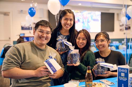 Alumni, from left, Derek Liu '17 and MBA '19, Sabrina Hallabay '19, Jennifer Tolentino '18 and MBA '21 and Christine Vergara '19 show off their swag.