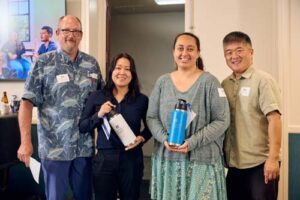 Drs. Dale Fryxell and Hans Chun pose with alumnae, Jasmine Cho, left, and Nicole Sagapolutele, who both won hydroflasks.