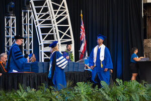 Ryan Chang receives his diploma from Chaminade President Lynn Babington, Ph.D.