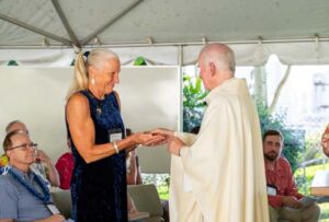 As part of the MEA Formation rituals, Fr. Martin Solma annoints the hands of Dr. Gail Grabowsky.