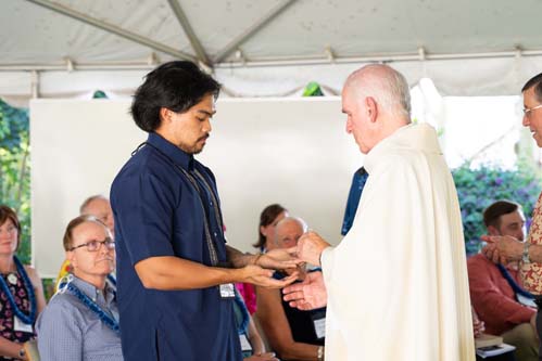 As part of the MEA Formation rituals, Fr. Martin Solma annoints the hands of Andrew Ancheta.
