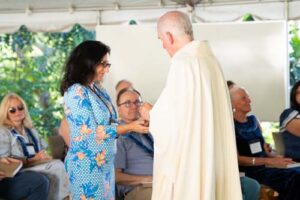 As part of the MEA Formation rituals, Fr. Martin Solma annoints the hands of Dr. Cheryl Edelson.