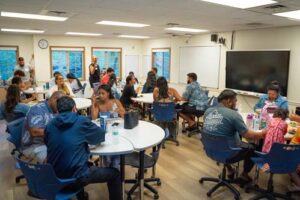 Alumni talked story and shared memories inside and outside a classroom at Brogan Hall.