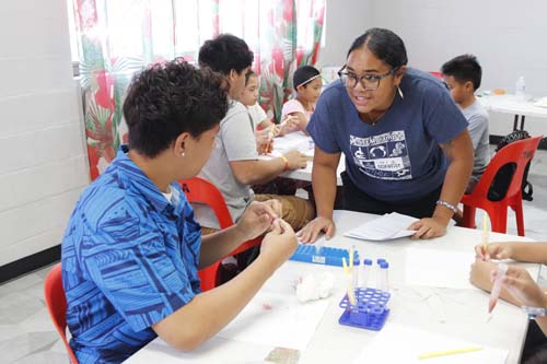 Rhea Jose, Outreach Coordinator for Chaminade’s United Nations CIFAL Center and I Am A Scientist–American Samoa (IAS-AS) program staff member, provides one-on-one help with one of the students.