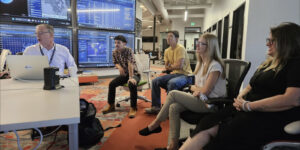 Joe Gerber (Space Command JCO), discusses his work, from left, Anson Ekau, Kai Garcia, Lt Hailey Spolar and Chloe Yap of the Maui Economic Development Board.
