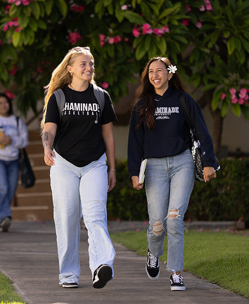 Two female Chaminade students walking on campus